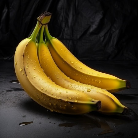 Bunch of bananas on a black background with water droplets.の素材