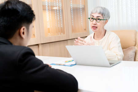 male job applicant Asians are Interview with an elderly Asian woman manager in an office in a...