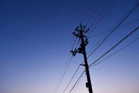 A utility pole and power lines at sunset