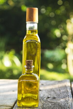 bottles of olive oil on wood with green backgroundの写真素材