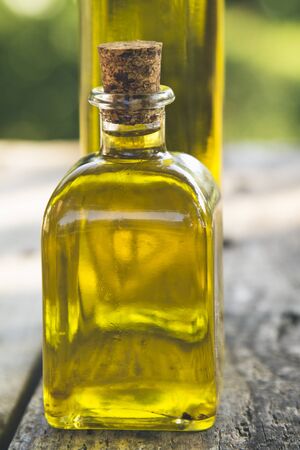 bottles of olive oil on wood with green backgroundの写真素材