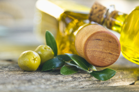 bottles of olive oil and olives on vintage tableの写真素材