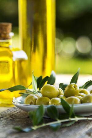 bowl of olives with green branchesの写真素材