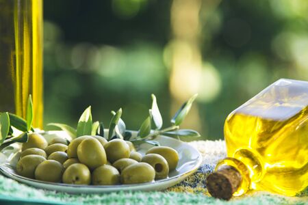 bowl of olives with green branchesの写真素材