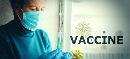 senior woman with disposable medical mask and syringe, concept of vaccine against covid-19 virus in elderly peopleの写真素材