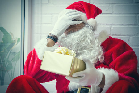 desperate santa claus with christmas gifts waiting for christmasの写真素材
