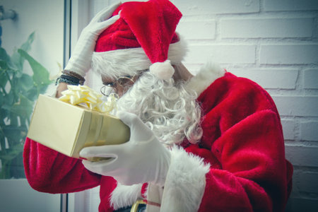 santa claus burdened with christmas gifts waiting for christmasの写真素材