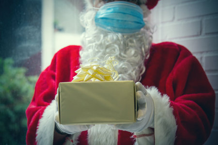 santa claus with medical mask and christmas giftの写真素材