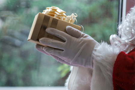 santa claus hands holding a gift box, merry christmas postcardの写真素材