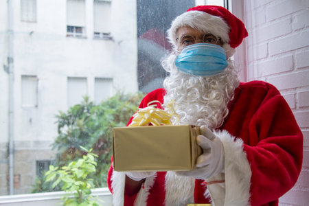 santa claus with medical mask and christmas giftの写真素材