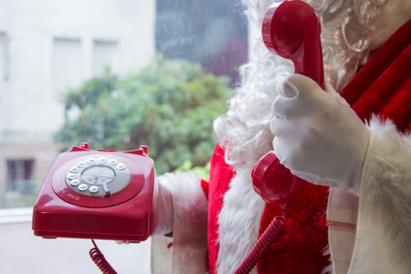 santa claus calling with a red vintage cord phoneの写真素材