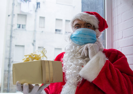 santa claus with medical mask and christmas giftの写真素材