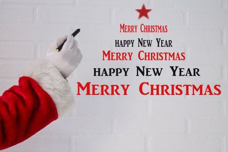 Santa Claus writing Christmas and New Year's congratulations with the penの写真素材