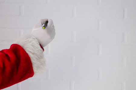 Santa Claus writing with the pen on the white brick wallの写真素材