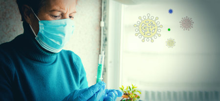 senior woman with disposable medical mask and syringe, concept of viru vaccine in elderly peopleの写真素材