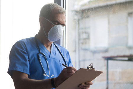 doctor with mask, stethoscope and reports, coronavirus virus concept and infectionsの写真素材