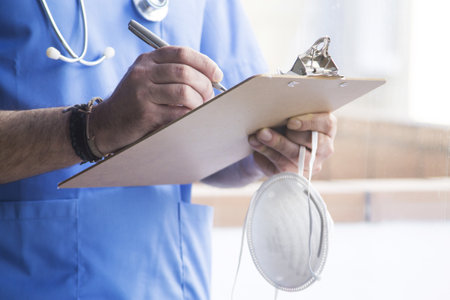 doctor with mask, stethoscope and reports, coronavirus virus concept and infectionsの写真素材