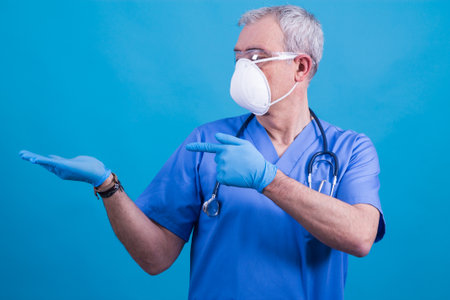 doctor with mask and glasses pointing or showingの写真素材