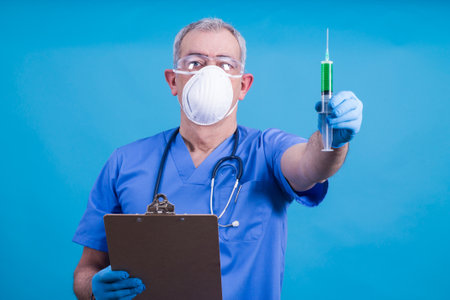 doctor with mask, stethoscope and injection, coronavirus virus concept and infectionsの写真素材