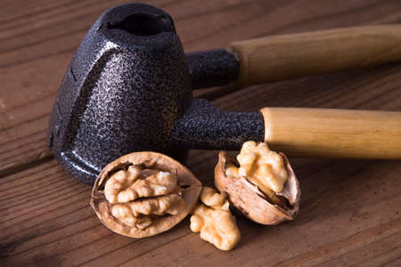 nutcracker and open walnuts on woodの写真素材