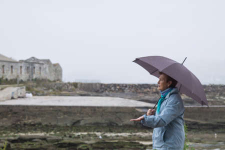 woman with umbrella walking in the rainの写真素材