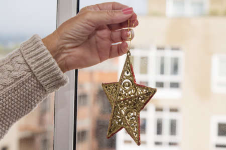 Christmas star decor in women hand. Christmas greeting card. Woman's hands hold christmas or new...