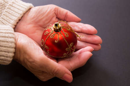 woman holding christmas ball in handsの写真素材