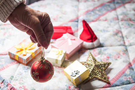 woman holding christmas ball with christmas decorations in background, christmas greetingの写真素材