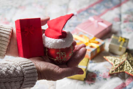 woman holding christmas ball with christmas decorations in background, christmas greetingの写真素材