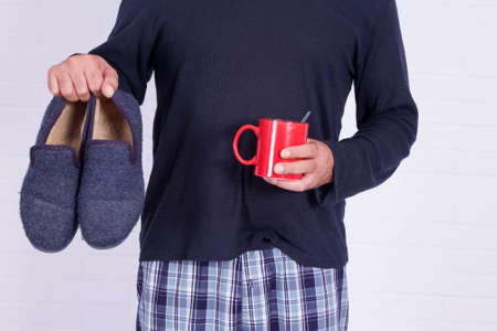 man with coffee cup and house slippersの写真素材