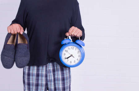 man with alarm clock and house slippers