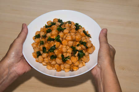 holding plate of chickpeas and spinach, diet and food conceptの写真素材