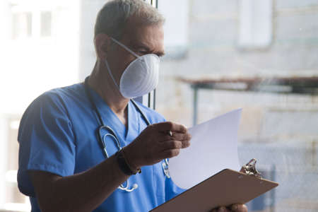 doctor with mask, stethoscope and reports, coronavirus virus concept and infectionsの写真素材