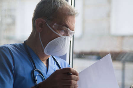 doctor with mask, stethoscope and reports, coronavirus virus concept and infectionsの写真素材