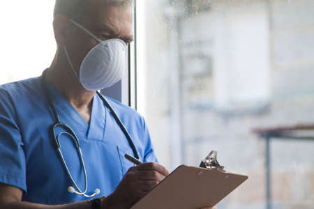 doctor with mask, stethoscope and reports, coronavirus virus concept and infectionsの写真素材