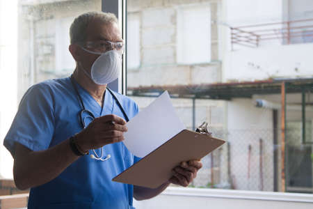 doctor with mask, stethoscope and reports, coronavirus virus concept and infectionsの写真素材