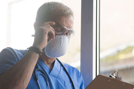 doctor with mask, stethoscope and reports, coronavirus virus concept and infectionsの写真素材