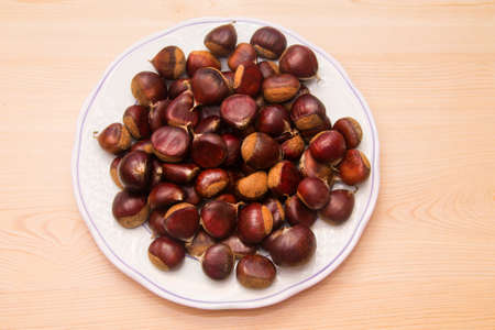 plate full of chestnuts on woodの写真素材