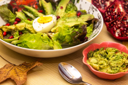 Avocado, egg and pomegranate salad with guacamole, diet and food conceptの写真素材