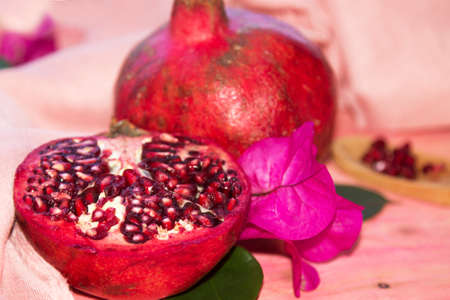 red pomegranate fruit and piece on pink backgroundの写真素材