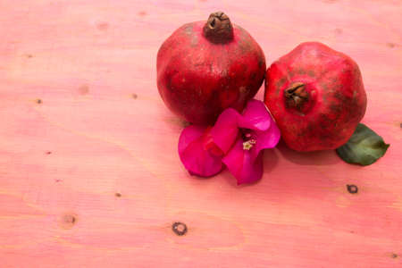 red pomegranate fruit on pink backgroundの写真素材