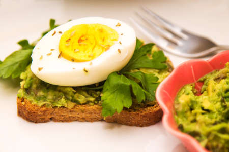 Guacamole toast and hard boiled egg with parsley, healthy diet conceptの写真素材
