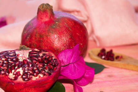 red pomegranate fruit and piece on pink backgroundの写真素材