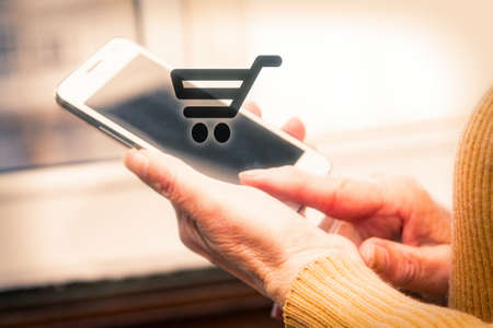 Woman holding a phone with a purchase icon. Online shoppingの写真素材