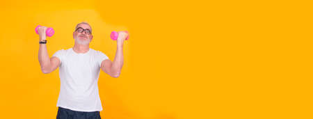 attractive mature man doing sports and showing muscle with dumbbellsの写真素材