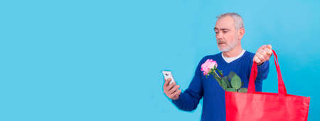 man doing online shopping on valentines day mobile phoneの写真素材
