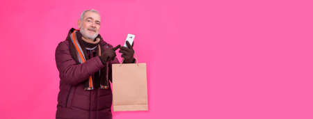 Shopping time. Modern senior man with shopping bags making a phone call. Consumerism, shopping, lifestyle conceptの写真素材