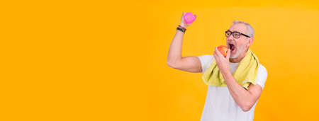 attractive senior man with measuring tape and apple, diet and health conceptの写真素材