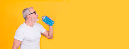 attractive adult man exhausted from sports drinkingの写真素材