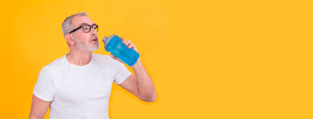 attractive adult man exhausted from sports drinkingの写真素材